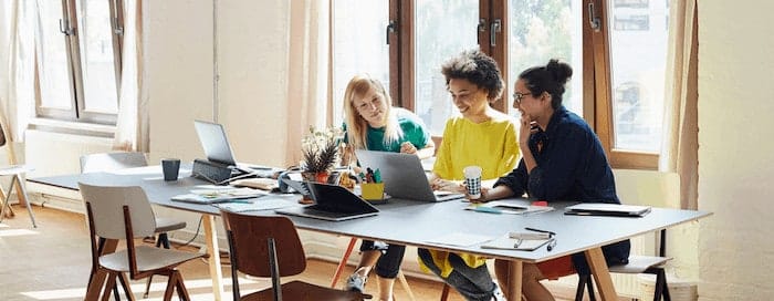 Three women looking at something on a laptop