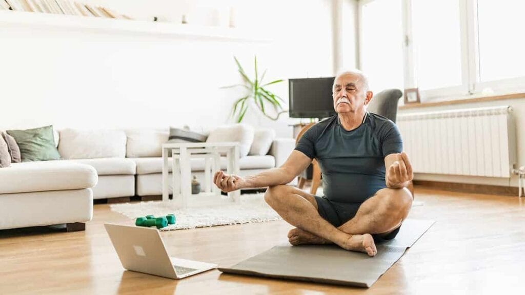 A man receiving instruction from a fitness coach online
