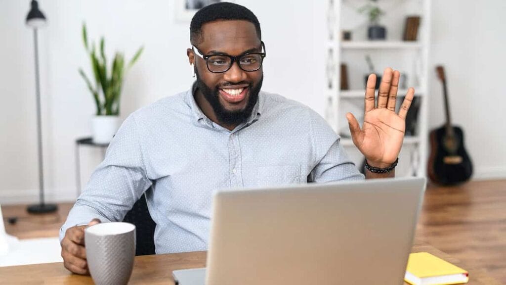 A coach greeting his client through a laptop