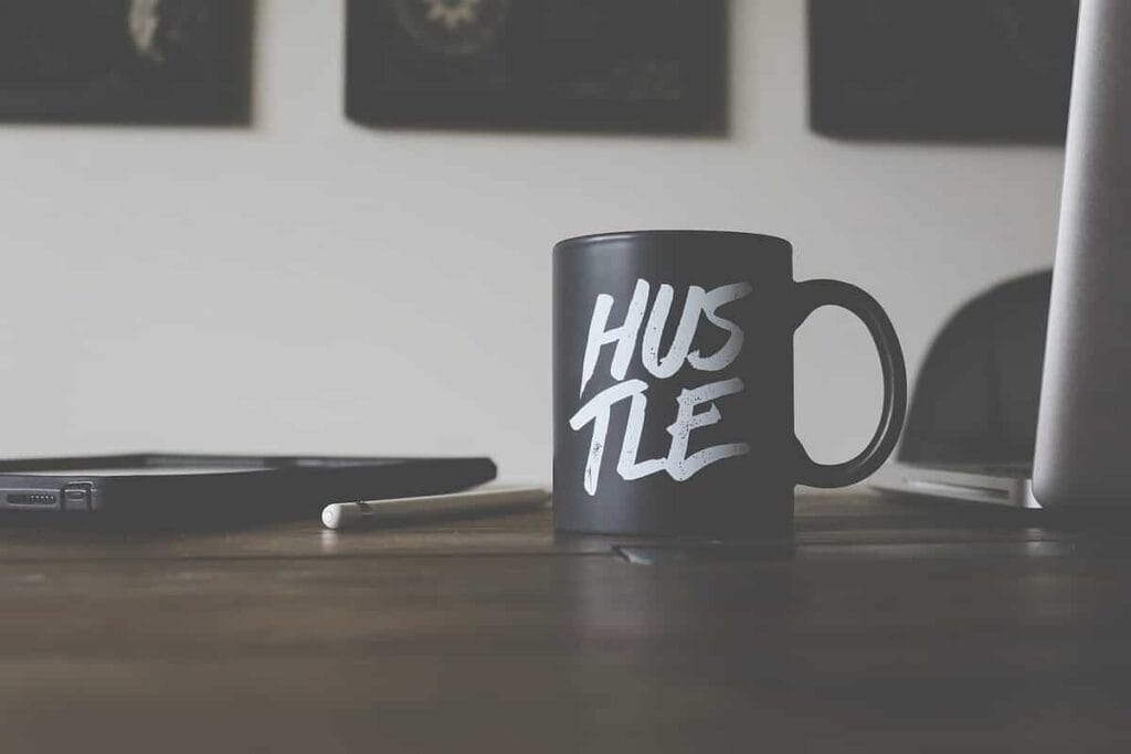A mug with the word "hustle" printed on it.